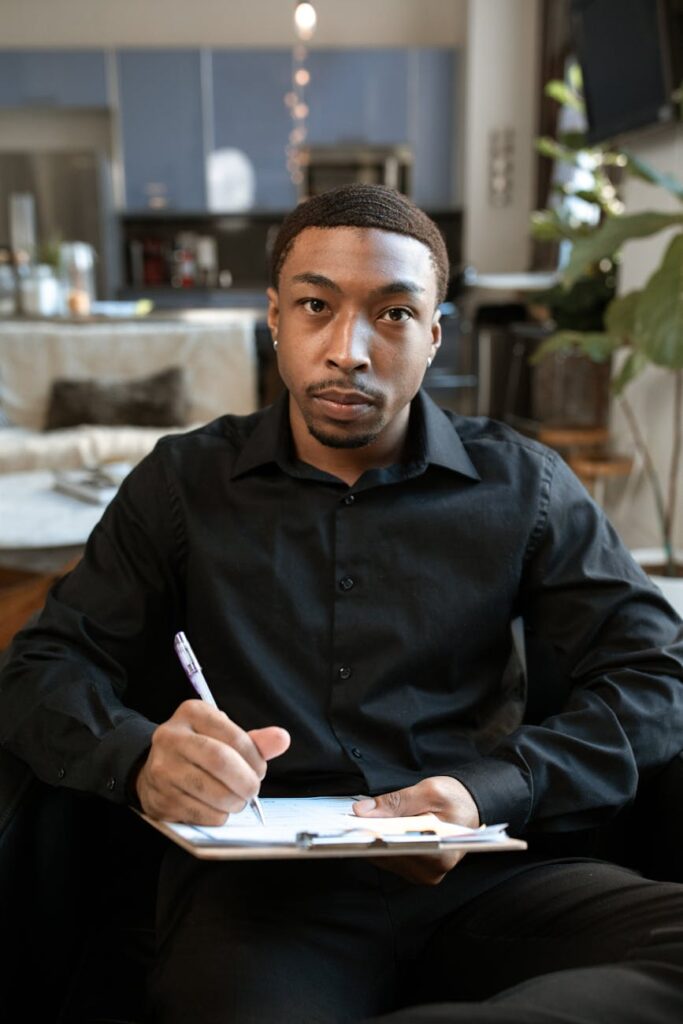 Um profissional de RH sobrecarregado por pilhas de currículos de papel em uma mesa de escritório.