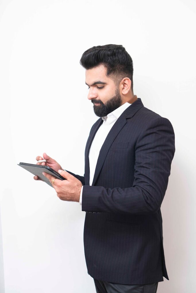 Gerente de RH moderno analisando dados em um tablet em um escritório iluminado.