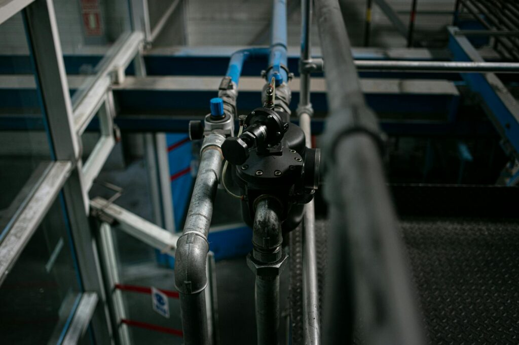 Detailed view of a metallic pipe system with valves in an industrial setting.